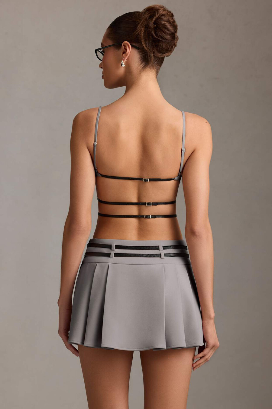 vestido curto plissado com cinto e costas abertas na cor cinza.