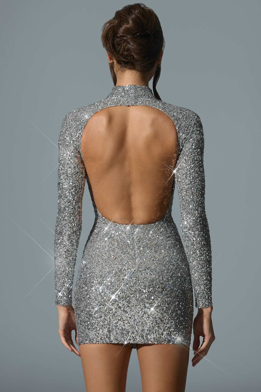 vestido curto prateado com decote nas costas e aplicações.