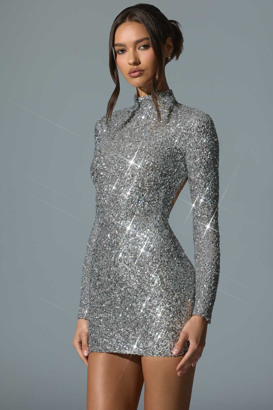 vestido curto prateado com decote nas costas e aplicações.