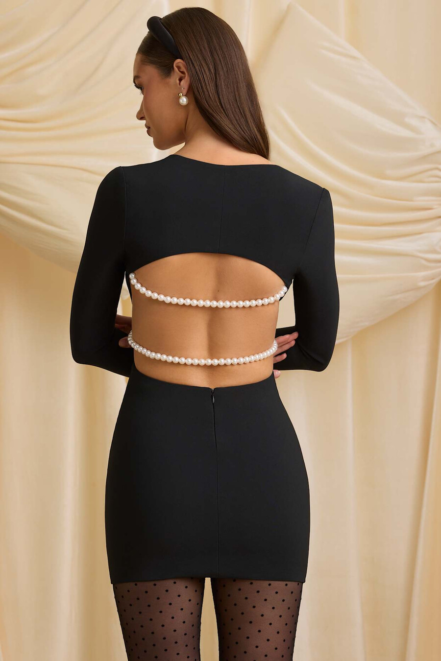 vestido curto preto com recortes e detalhes em pérola.