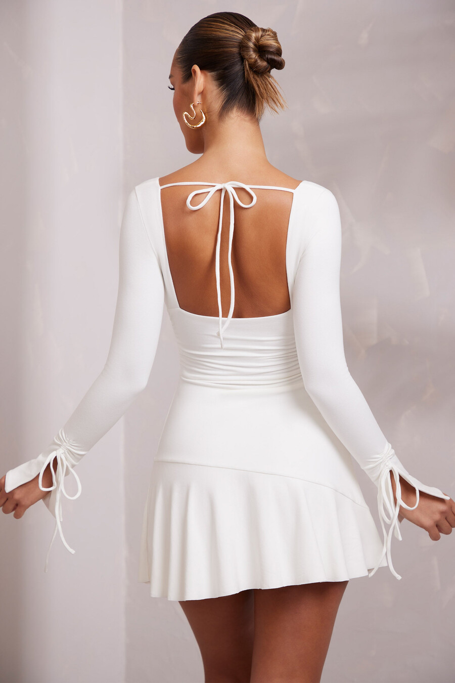 vestido curto evasê franzido de manga comprida na cor branca.