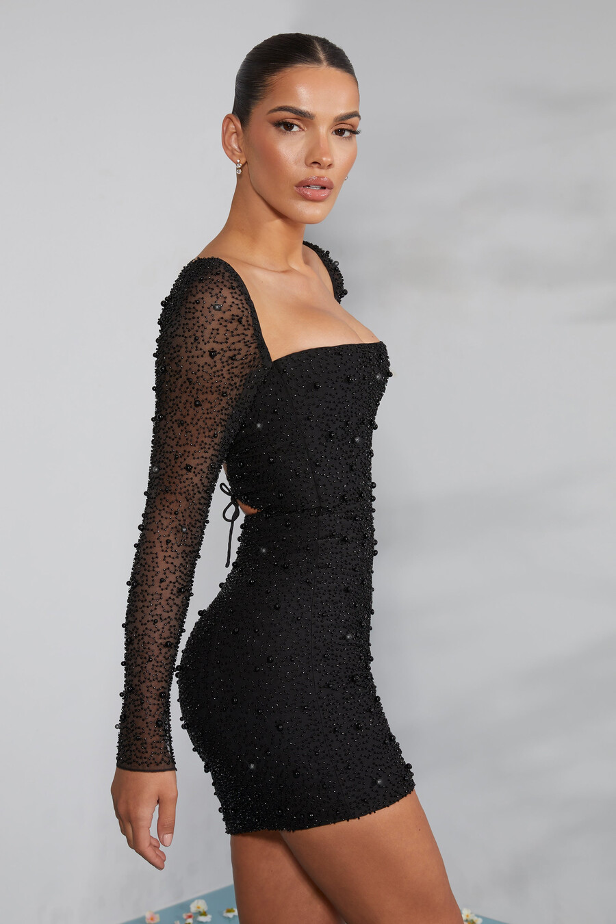 vestido curto preto com espartilho bordado e mangas compridas.