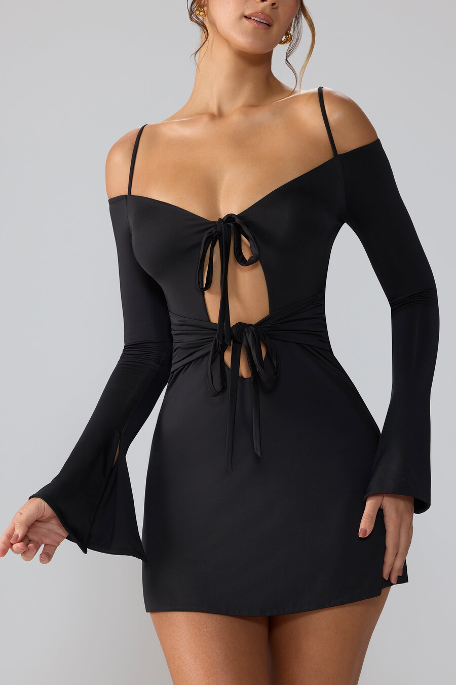 vestido curto de malha esvoaçante com mangas compridas e recortes na cor preta.