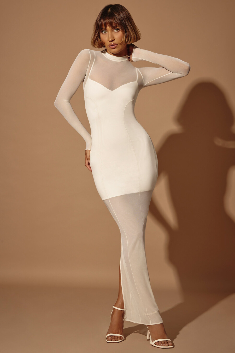 vestido longo transparente com camadas e mangas compridas na cor marfim.