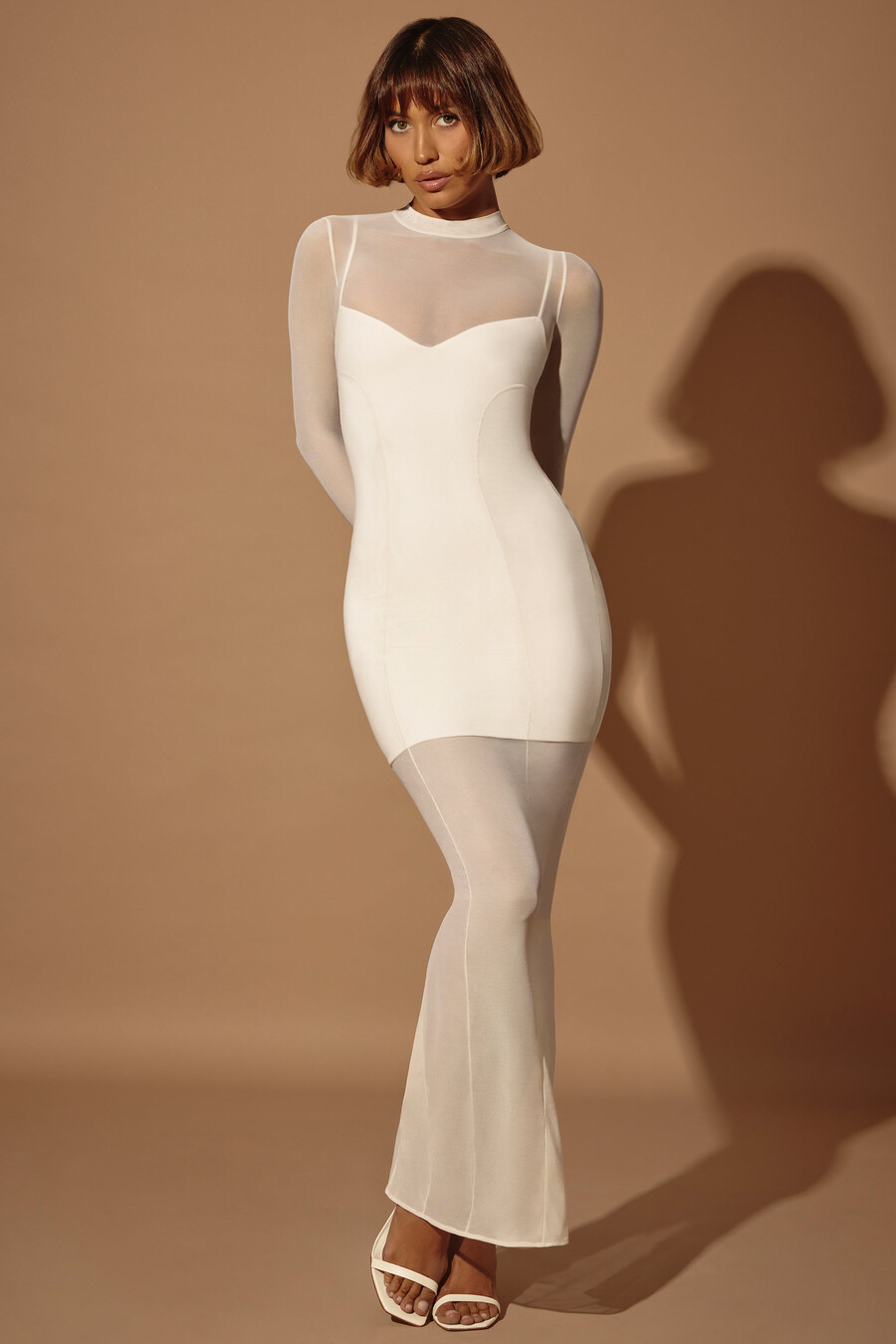 vestido longo transparente com camadas e mangas compridas na cor marfim.