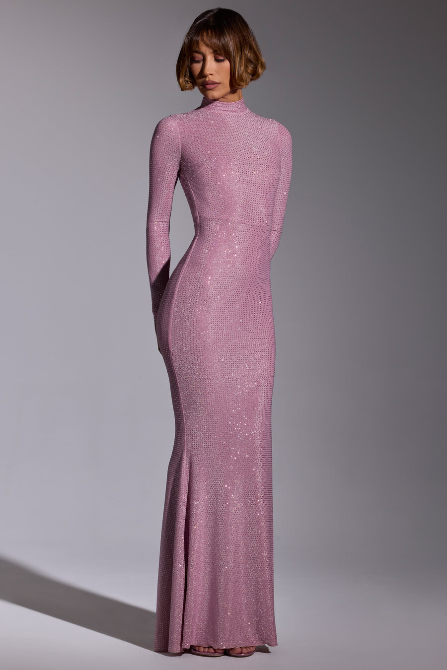 vestido de noite longo com mangas compridas e detalhes bordados em rosa claro.