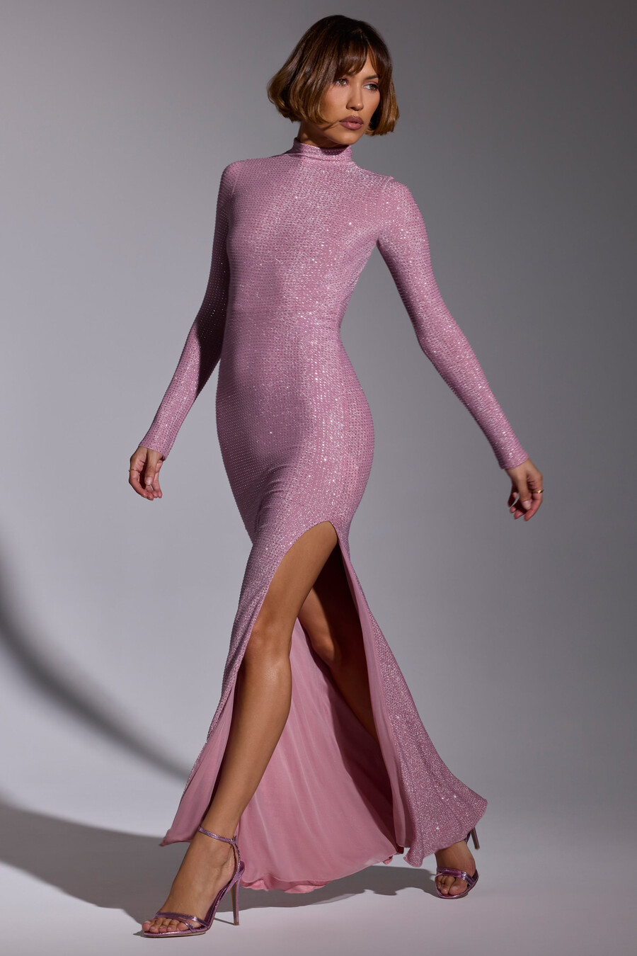 vestido de noite longo com mangas compridas e detalhes bordados em rosa claro.