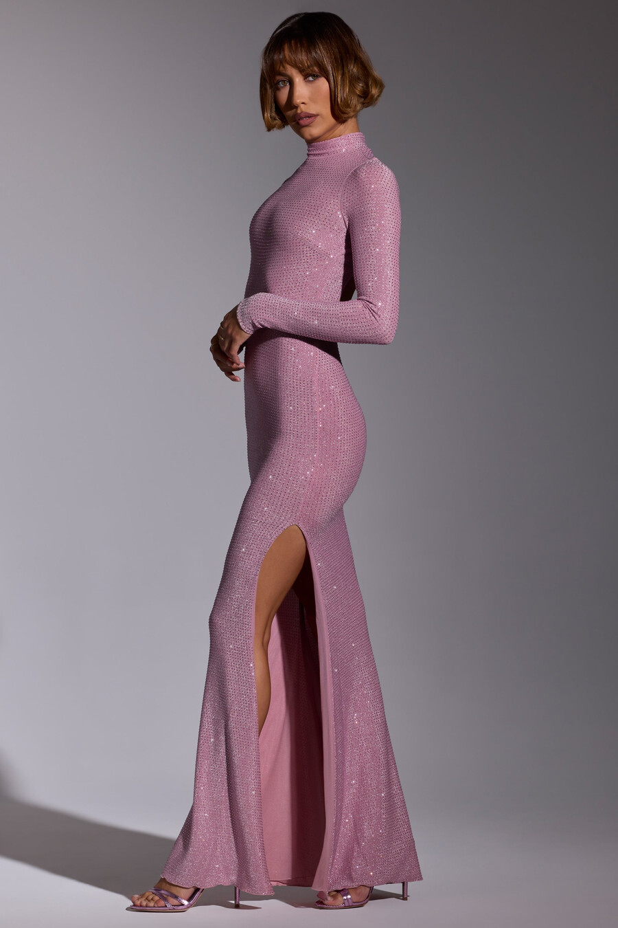 vestido de noite longo com mangas compridas e detalhes bordados em rosa claro.