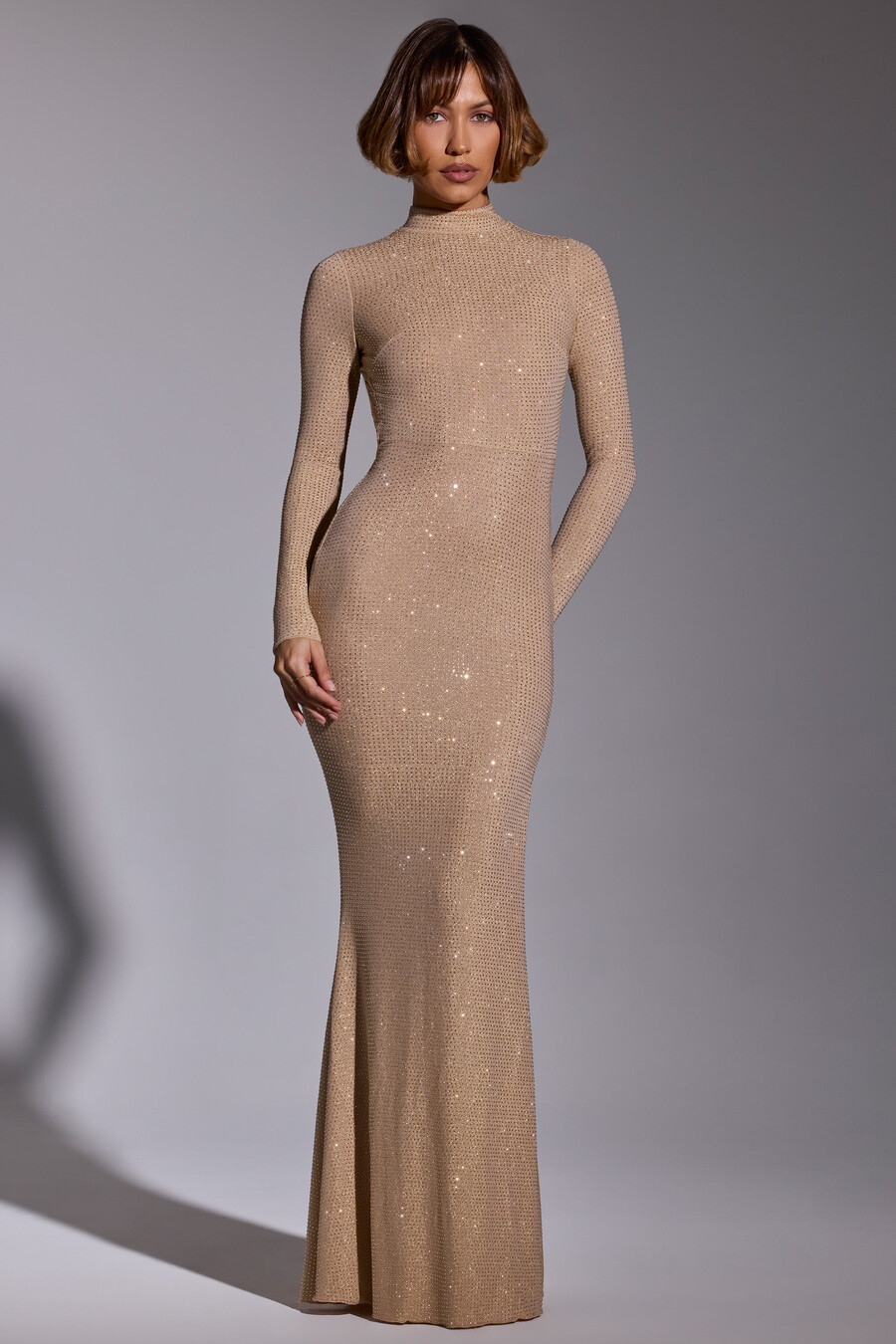 vestido de noite comprido com mangas compridas e detalhes em dourado.