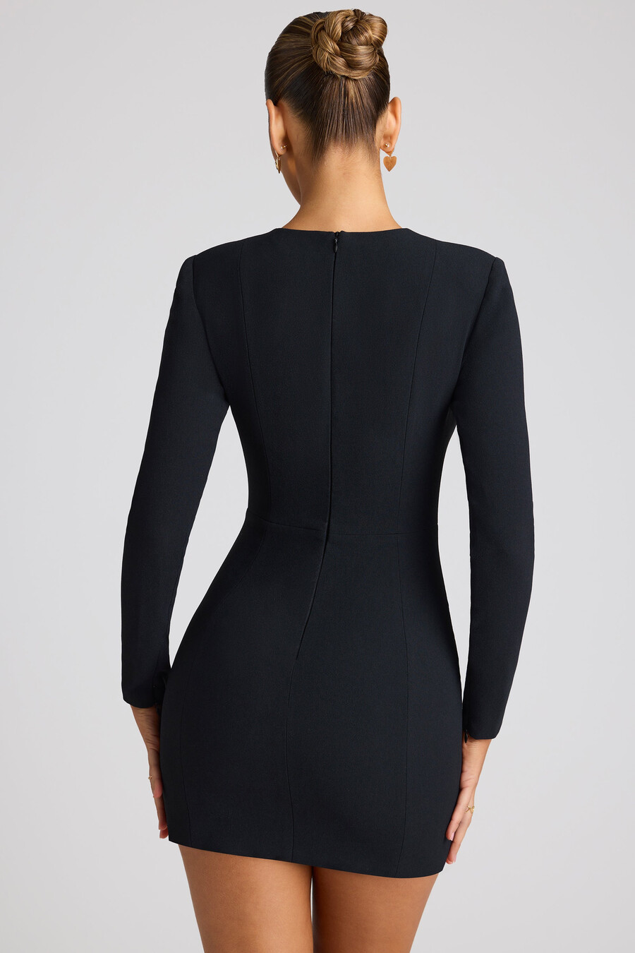 vestido curto preto com mangas compridas e recorte em formato de coração.