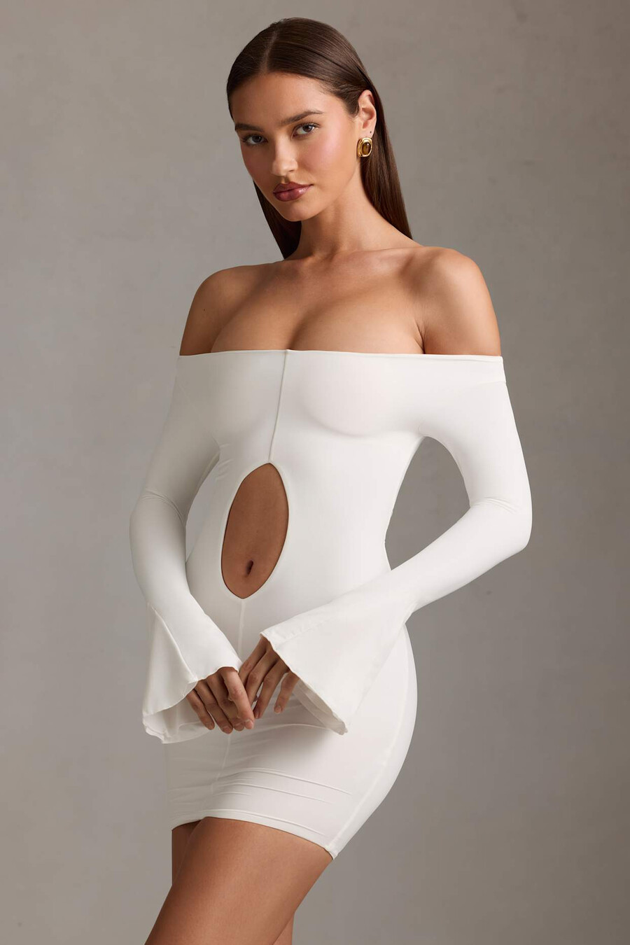 vestido curto branco com recortes e ombros à mostra.