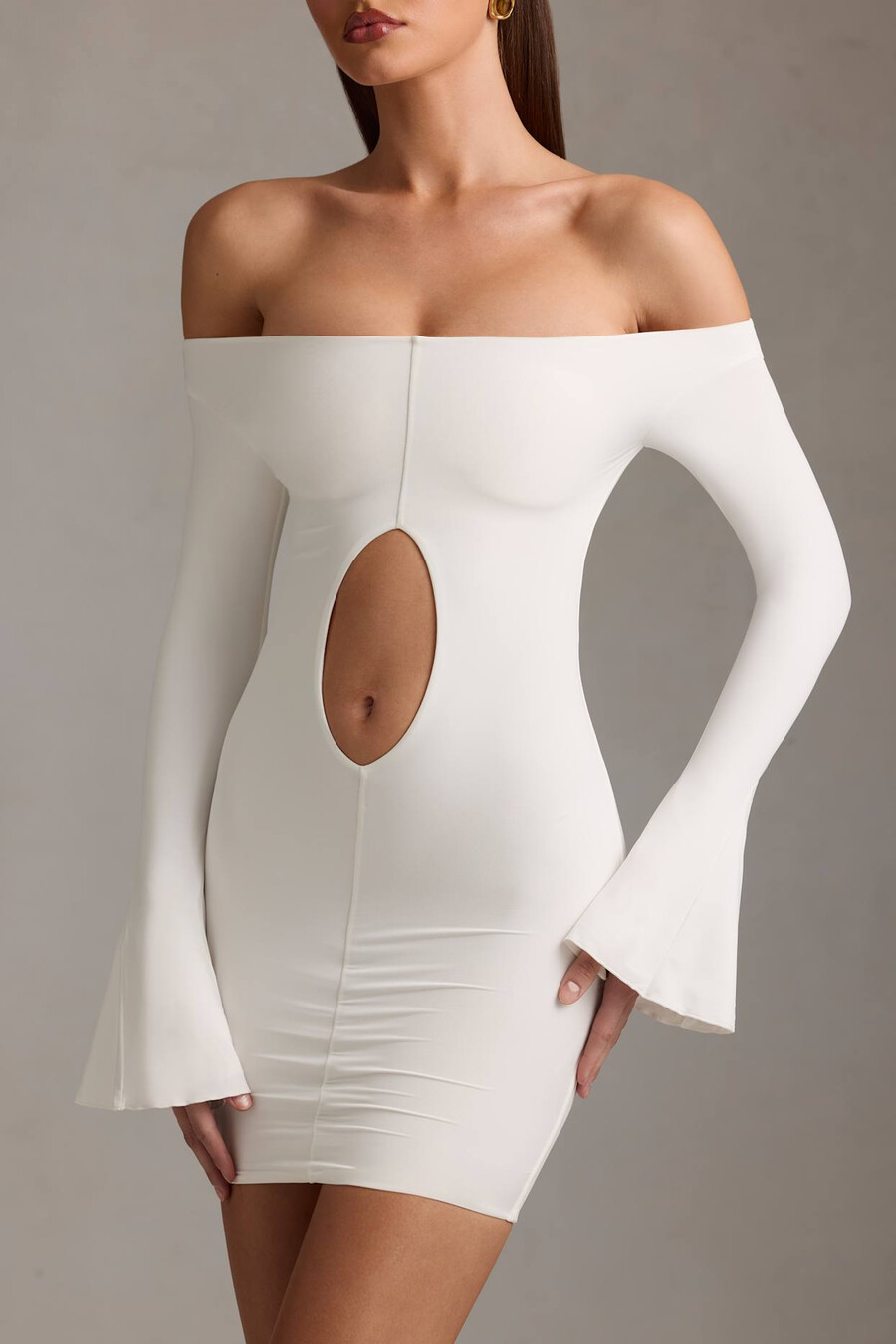 vestido curto branco com recortes e ombros à mostra.