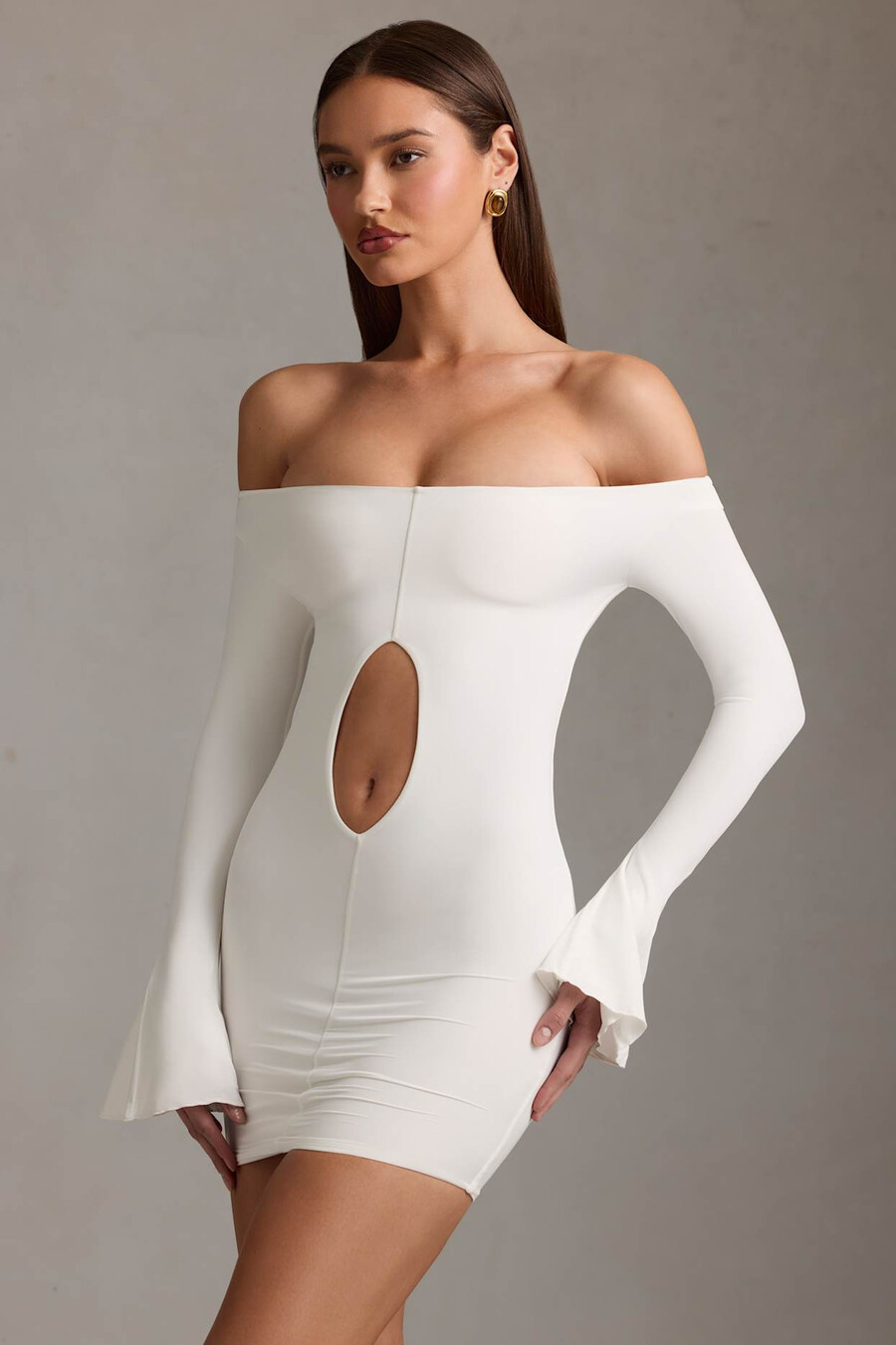 vestido curto branco com recortes e ombros à mostra.