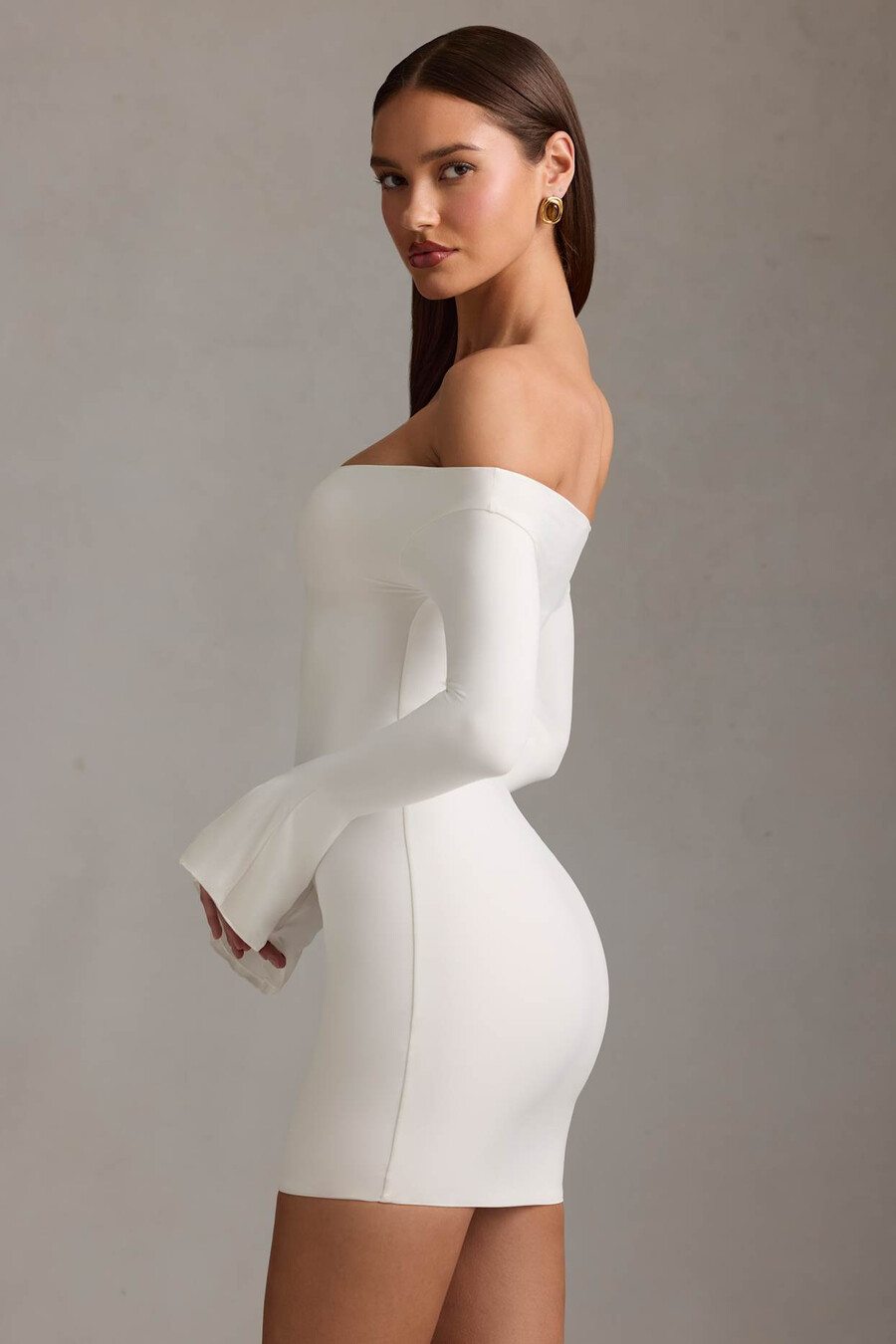 vestido curto branco com recortes e ombros à mostra.