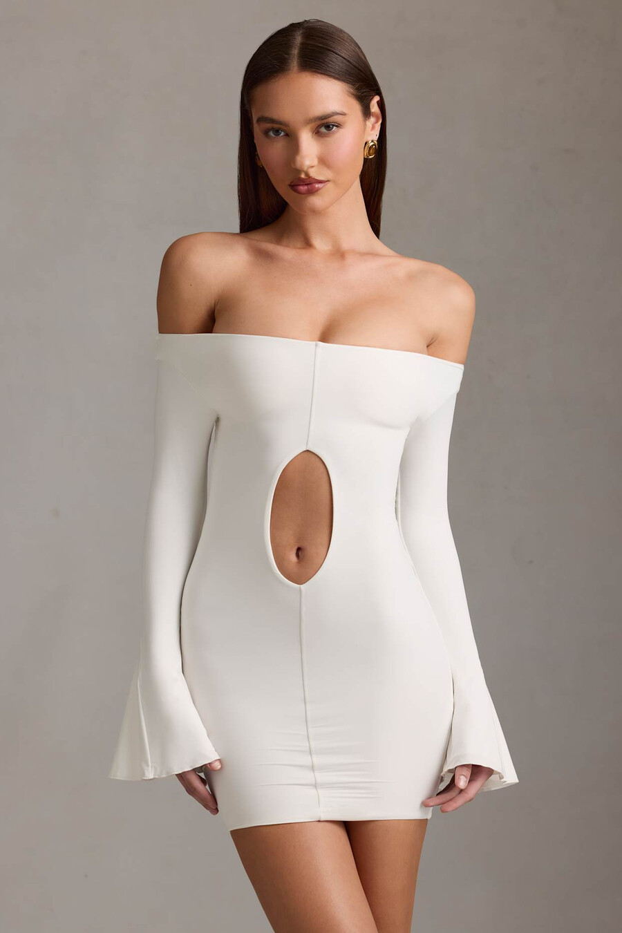 vestido curto branco com recortes e ombros à mostra.