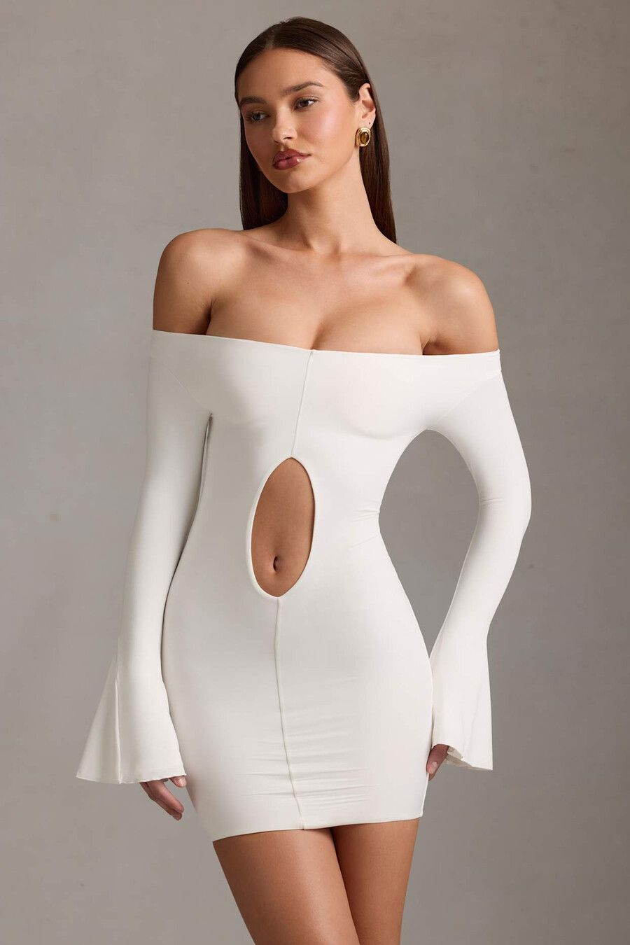 vestido curto branco com recortes e ombros à mostra.