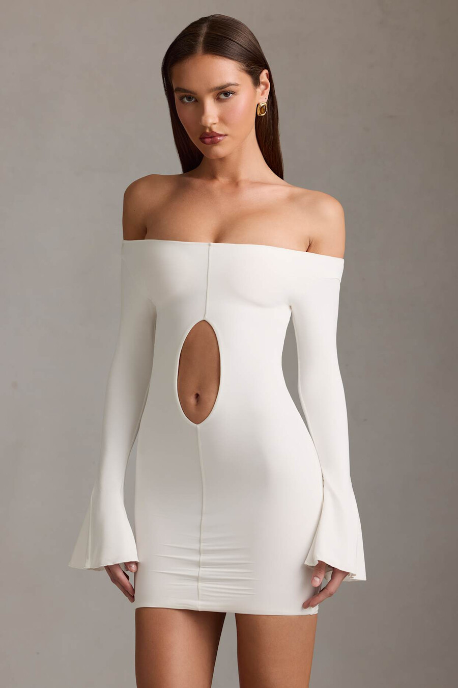vestido curto branco com recortes e ombros à mostra.