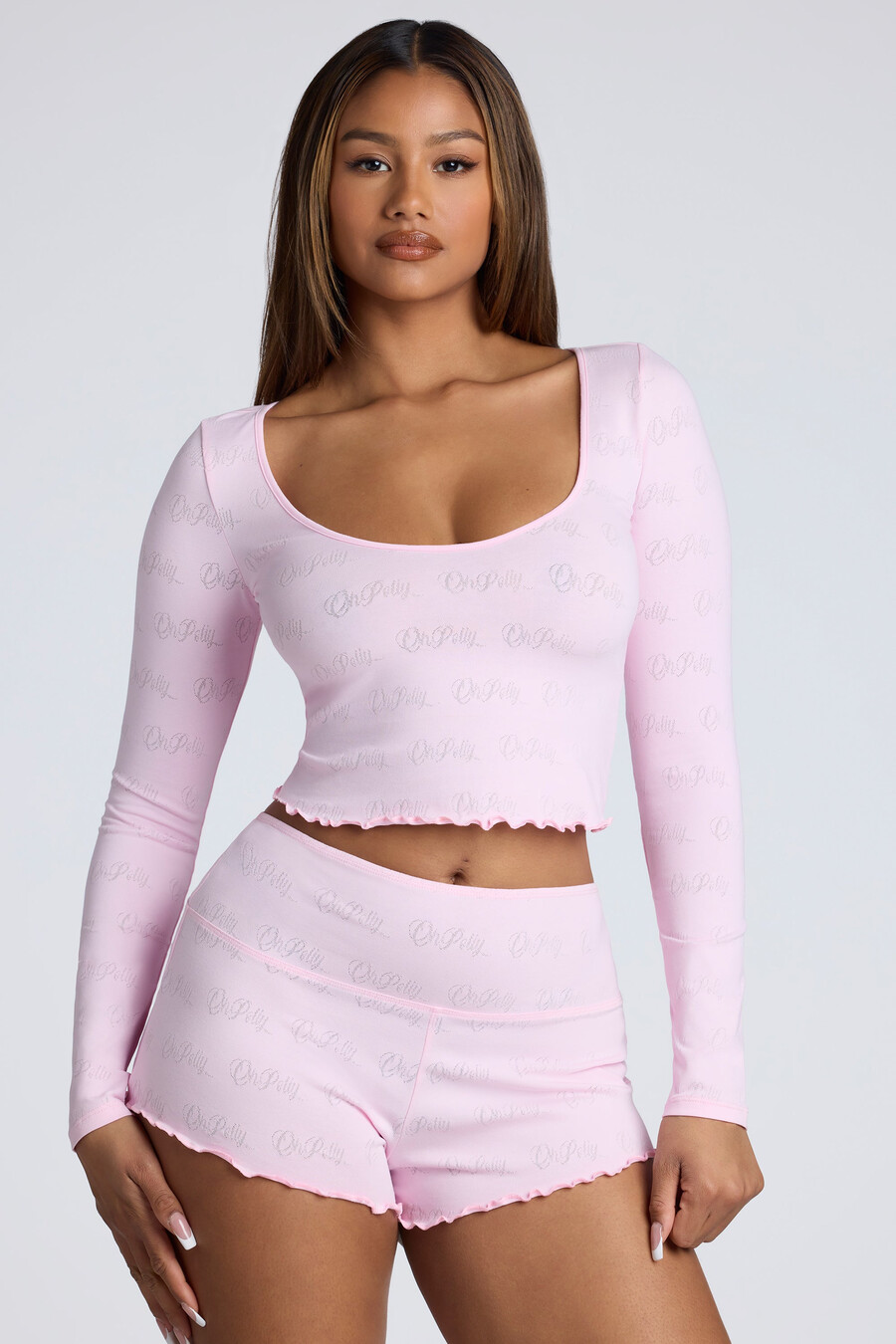 shorts curtos de cintura média com detalhes em ponto ajour na cor rosa bebê.