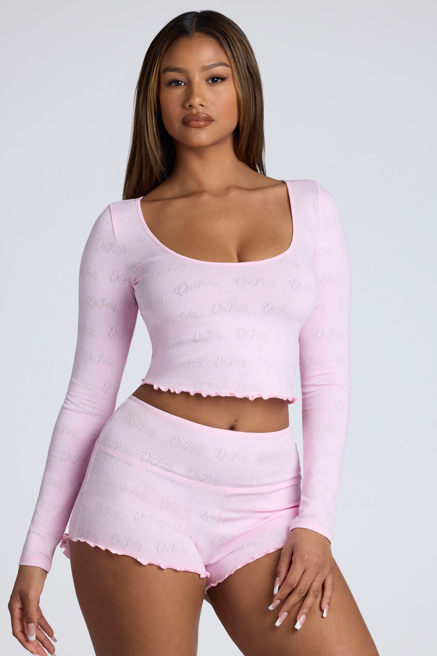 shorts curtos de cintura média com detalhes em ponto ajour na cor rosa bebê.
