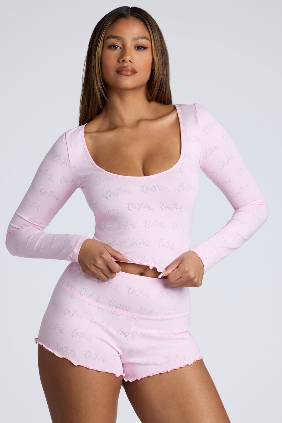 shorts curtos de cintura média com detalhes em ponto ajour na cor rosa bebê.