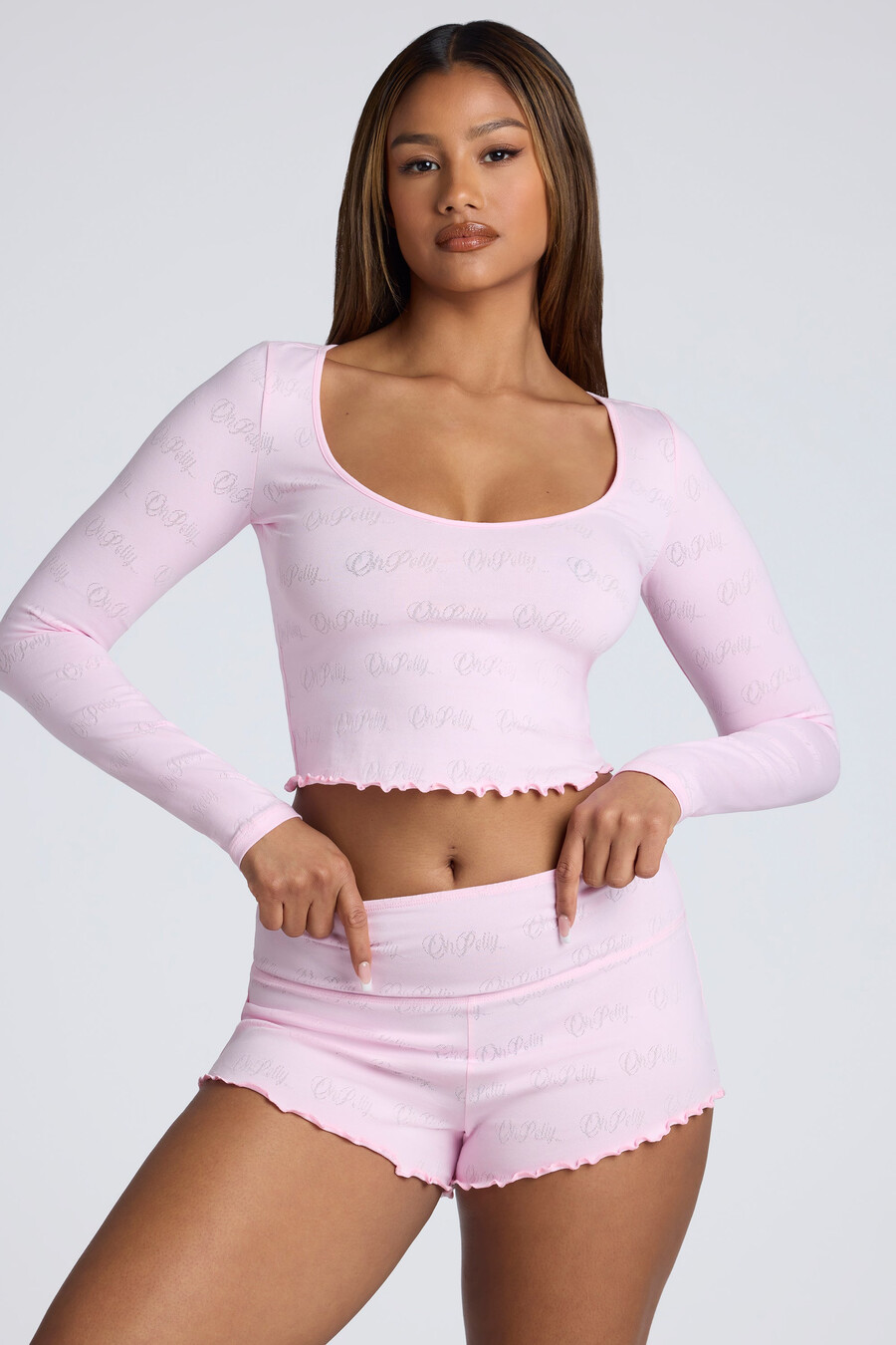 shorts curtos de cintura média com detalhes em ponto ajour na cor rosa bebê.