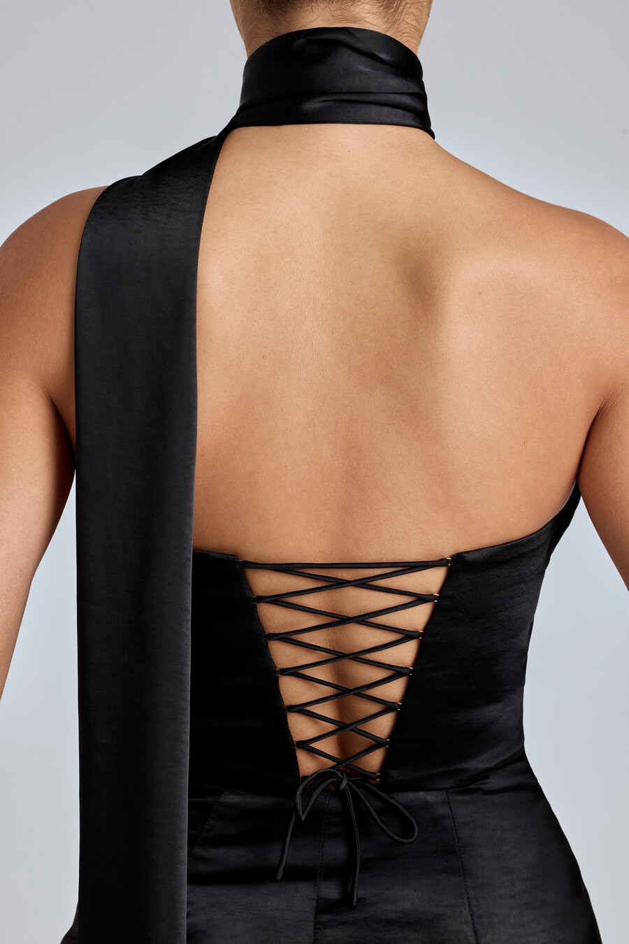 vestido curto de cetim preto com decote halter drapeado.