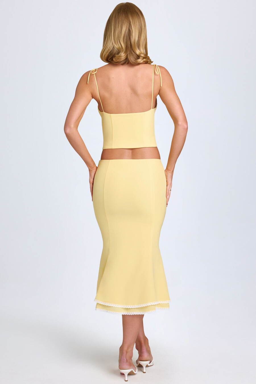 saia midi de cintura média com detalhes em renda na cor amarelo pastel.