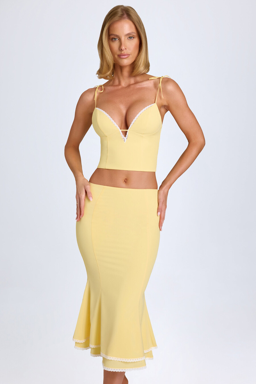 saia midi de cintura média com detalhes em renda na cor amarelo pastel.