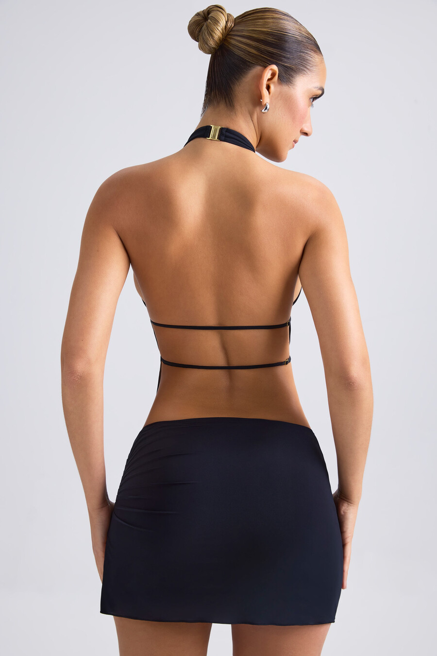 top cropped com decote halter e recortes franzidos na cor preta.