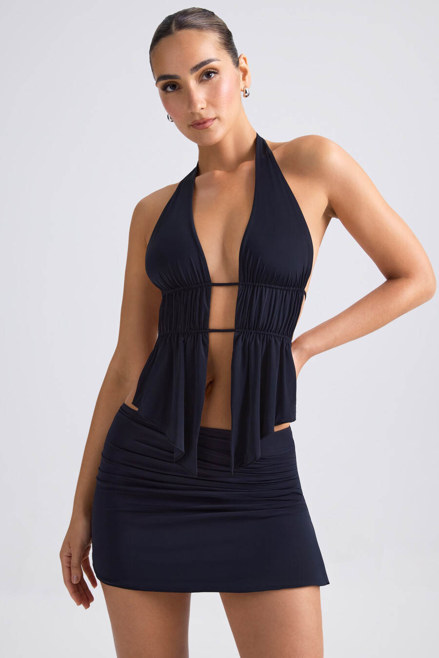 top cropped com decote halter e recortes franzidos na cor preta.