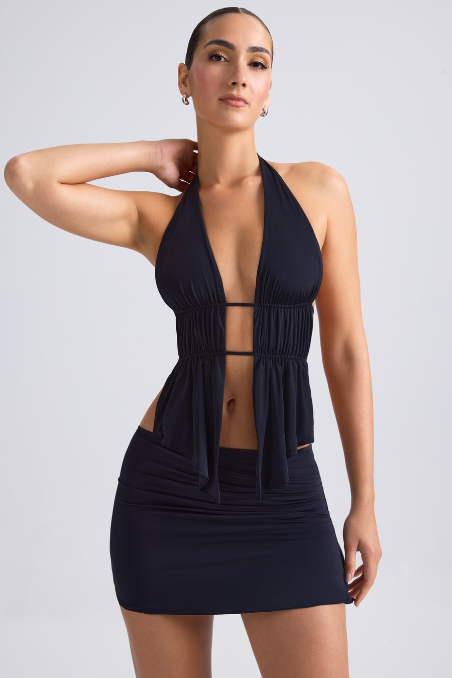top cropped com decote halter e recortes franzidos na cor preta.