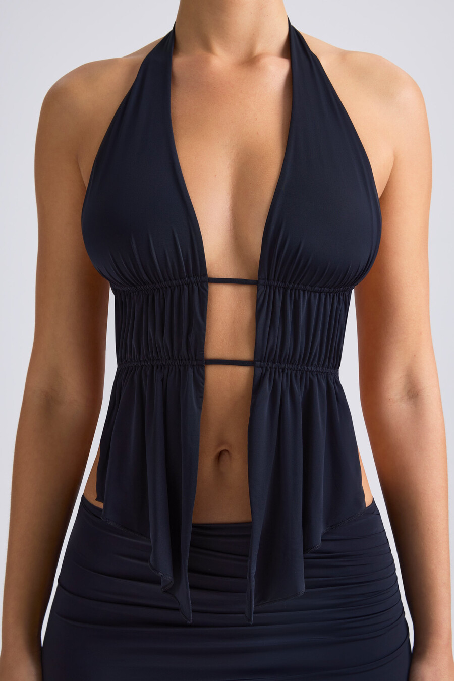 top cropped com decote halter e recortes franzidos na cor preta.