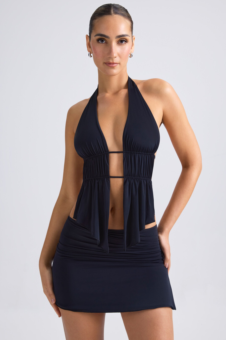 top cropped com decote halter e recortes franzidos na cor preta.