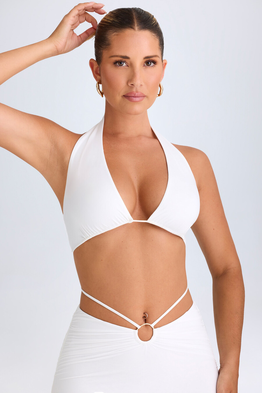 top cropped com decote halter e detalhes metálicos na cor branca.