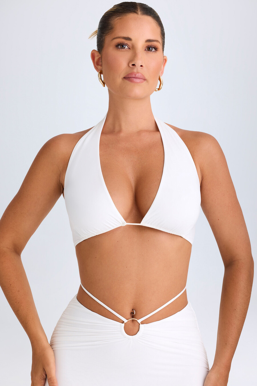 top cropped com decote halter e detalhes metálicos na cor branca.