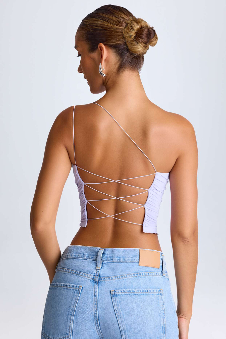 blusa de um ombro só com amarração em cadarço na cor lilás suave.