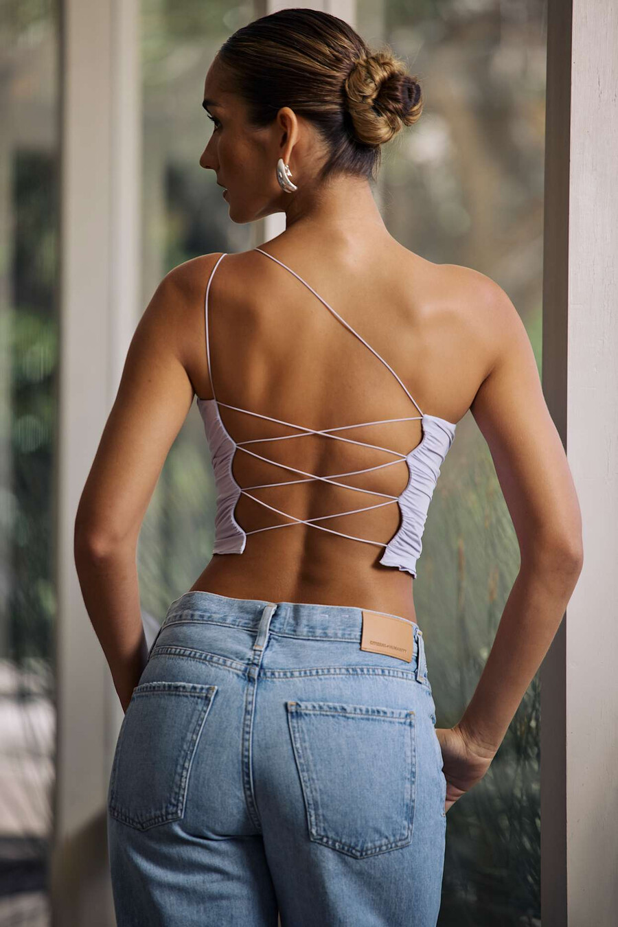 blusa de um ombro só com amarração em cadarço na cor lilás suave.