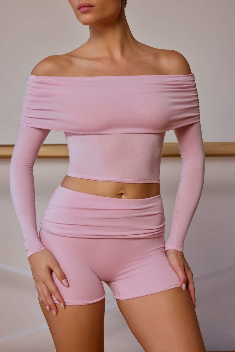 blusa transparente de manga comprida com ombros à mostra em tom rosa claro.