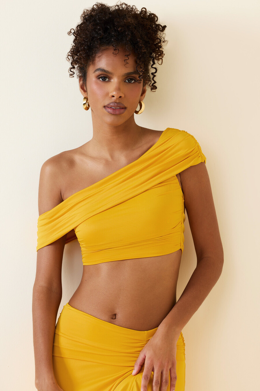 top cropped assimétrico com decote ombro a ombro e franzido em amarelo dourado