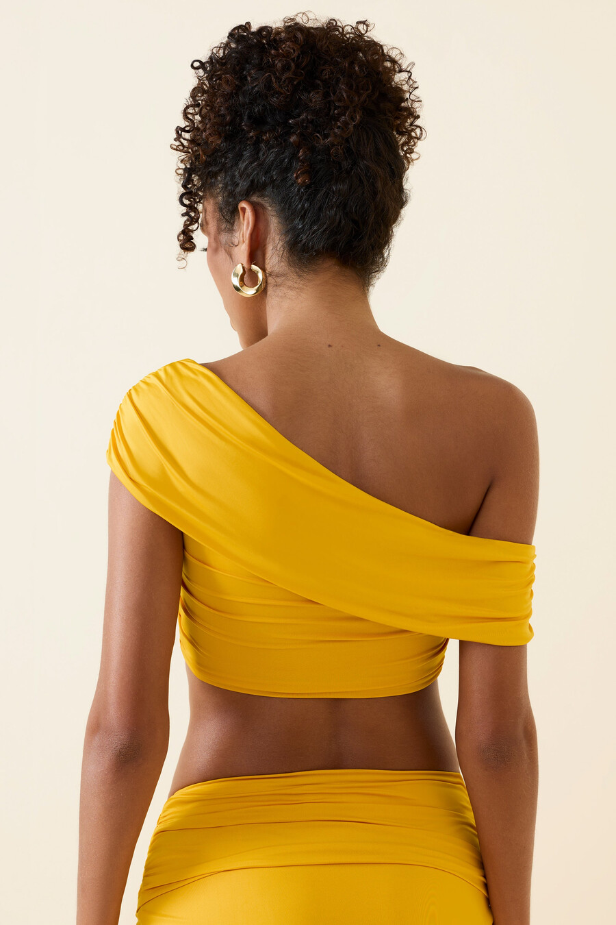 top cropped assimétrico com decote ombro a ombro e franzido em amarelo dourado