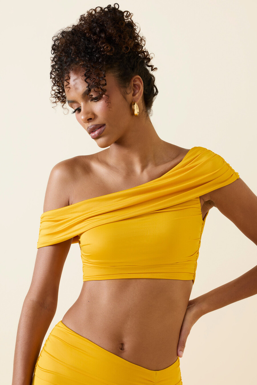 top cropped assimétrico com decote ombro a ombro e franzido em amarelo dourado