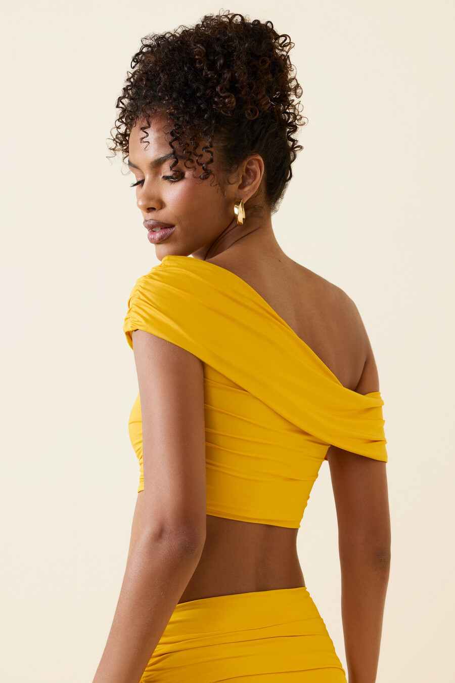top cropped assimétrico com decote ombro a ombro e franzido em amarelo dourado
