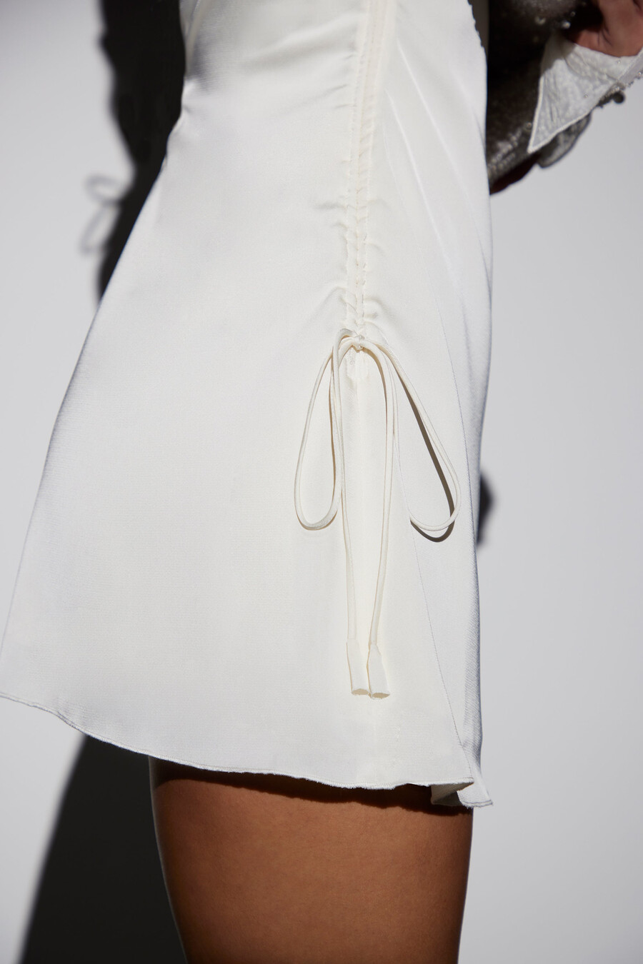 vestido curto evasê de manga comprida com detalhes brilhantes na cor branca.