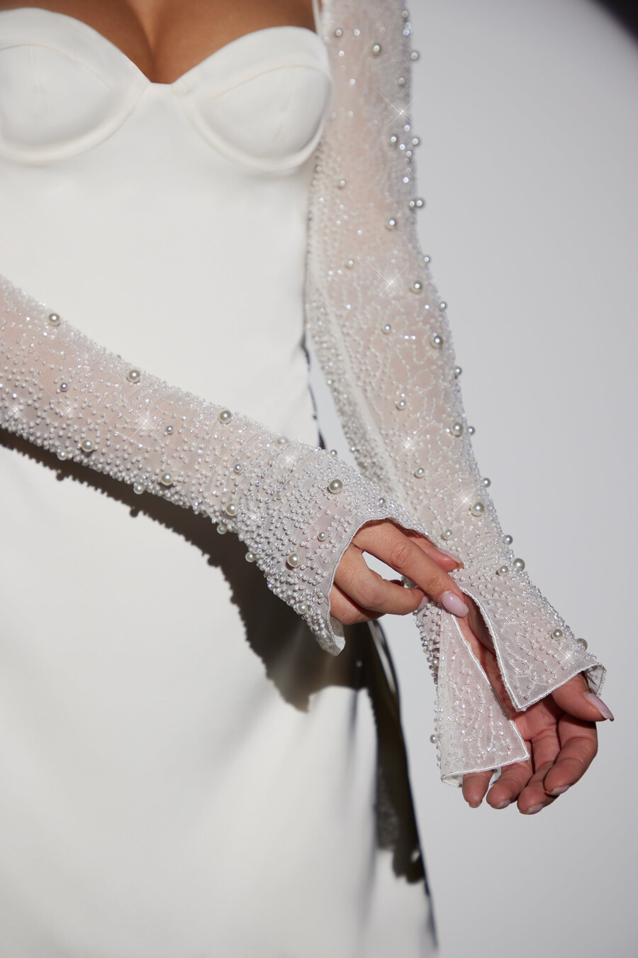 vestido curto evasê de manga comprida com detalhes brilhantes na cor branca.