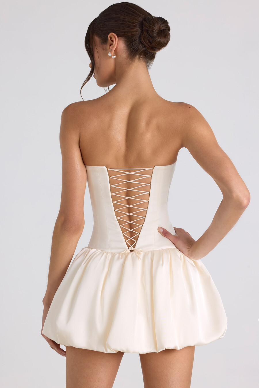 vestido curto estilo corset com barra balonê e amarração nas costas na cor marfim.