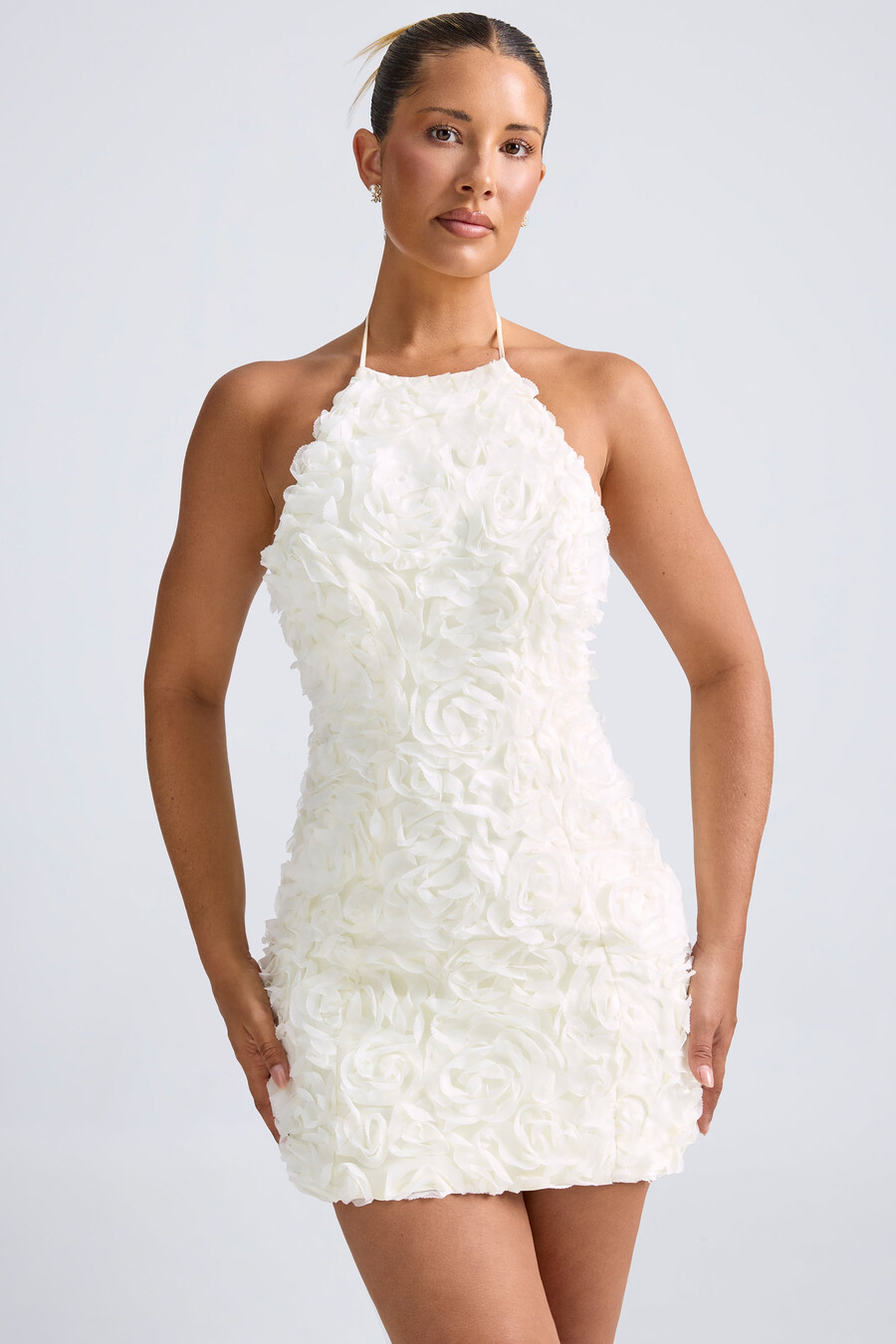 vestido curto evasê com decote halter e apliques florais na cor branca.