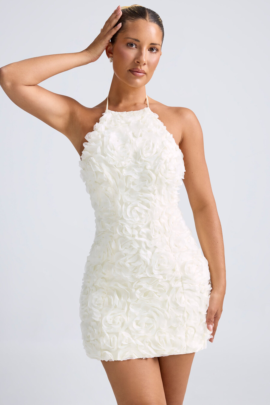 vestido curto evasê com decote halter e apliques florais na cor branca.