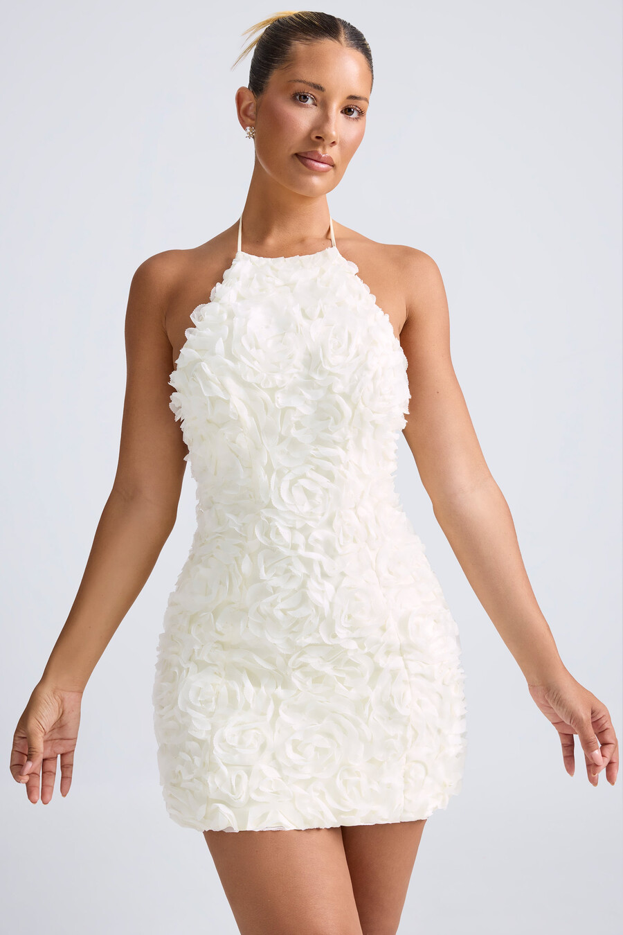 vestido curto evasê com decote halter e apliques florais na cor branca.