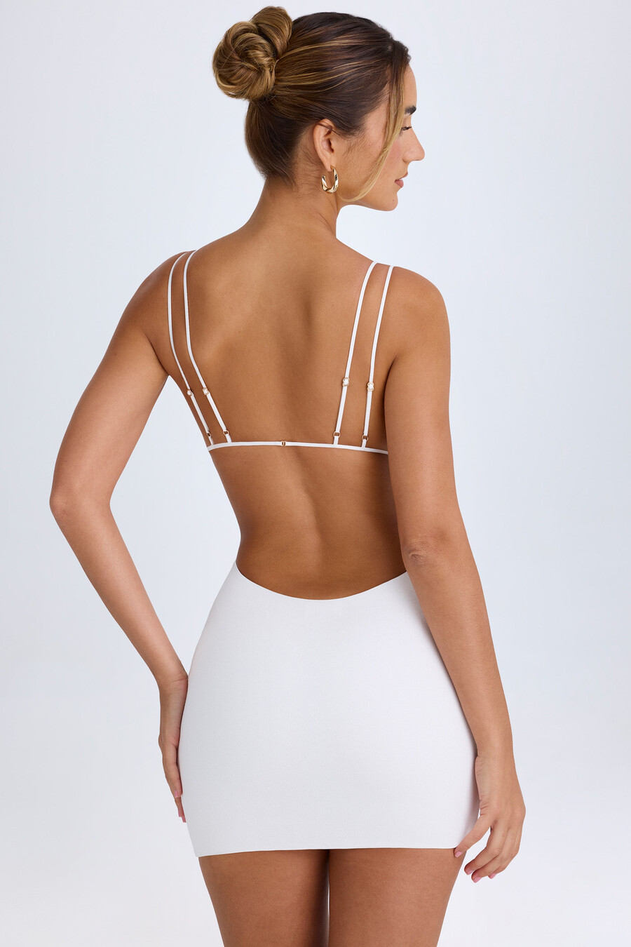 vestido curto branco com recortes e costas abertas.